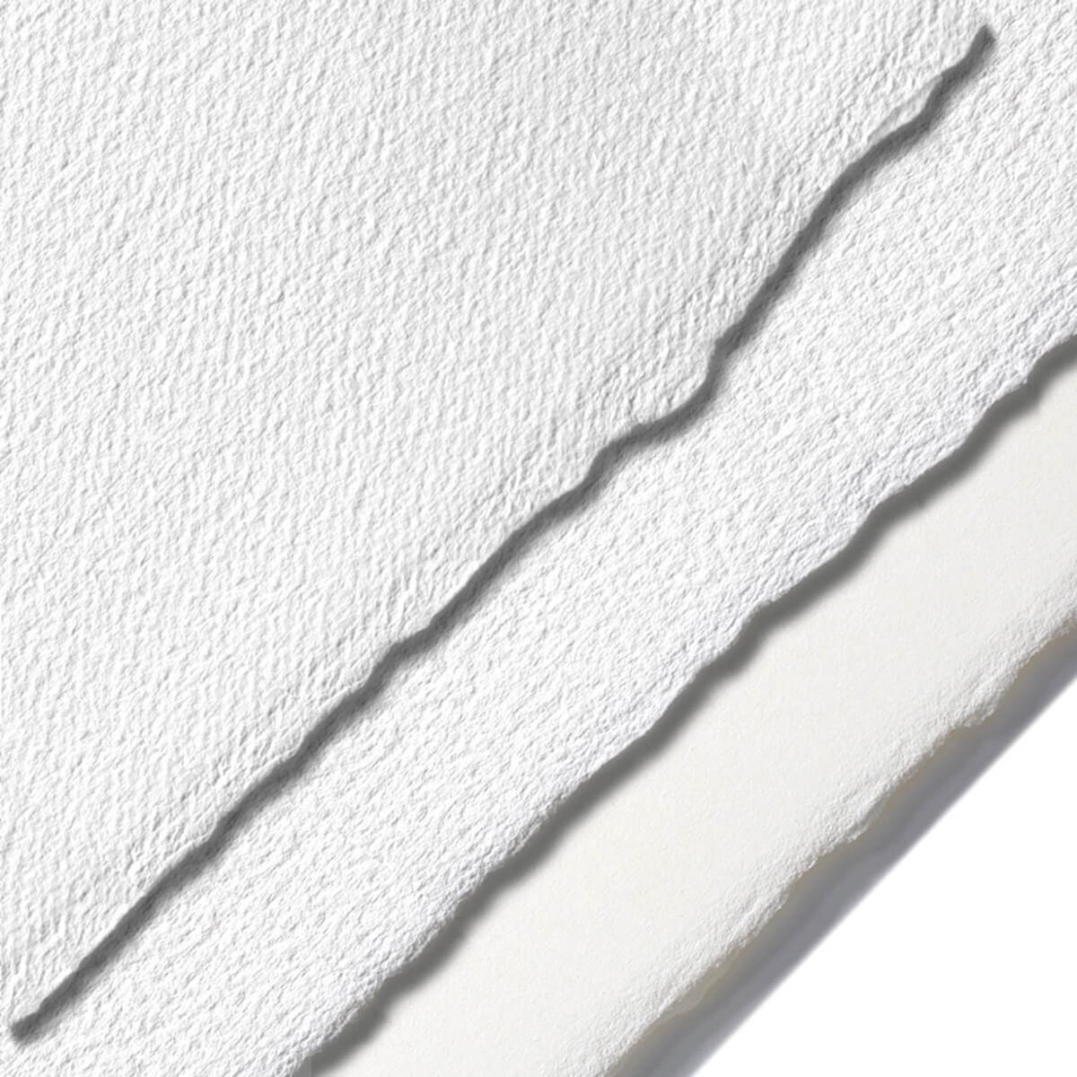Close-up of the torn deckle edges of two sheets of heavy white cotton fine art paper